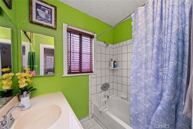 a bathroom with a sink mirror and tub
