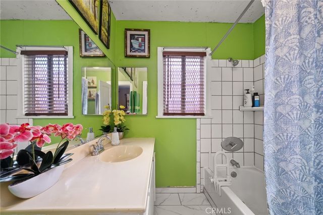 a bathroom with a sink mirror and tub
