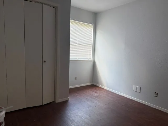 an empty room with wooden floor and closet