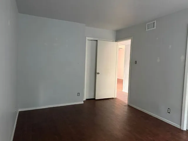 an empty room with wooden floor and closet