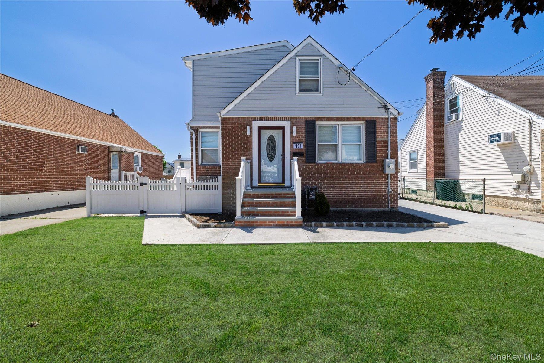 191 Raff Avenue Mineola, NY 11501 - Photo 2 of 25 a front view of a house with a yard and garage