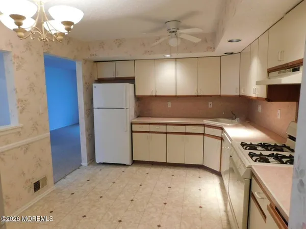 a kitchen with a refrigerator and a stove top oven