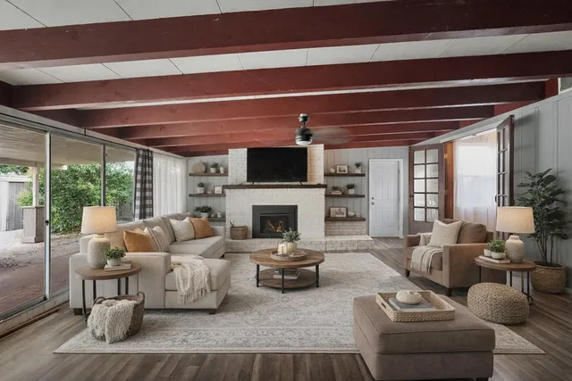 a living room with furniture a fireplace and a large window
