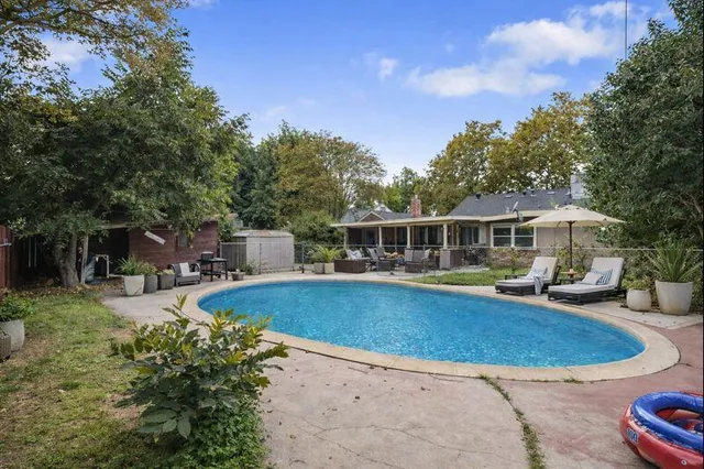 a view of a house with swimming pool and sitting area