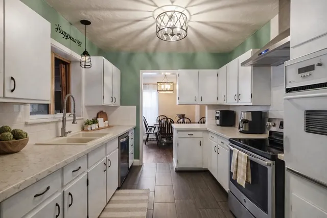 a kitchen with stainless steel appliances a sink stove and cabinets