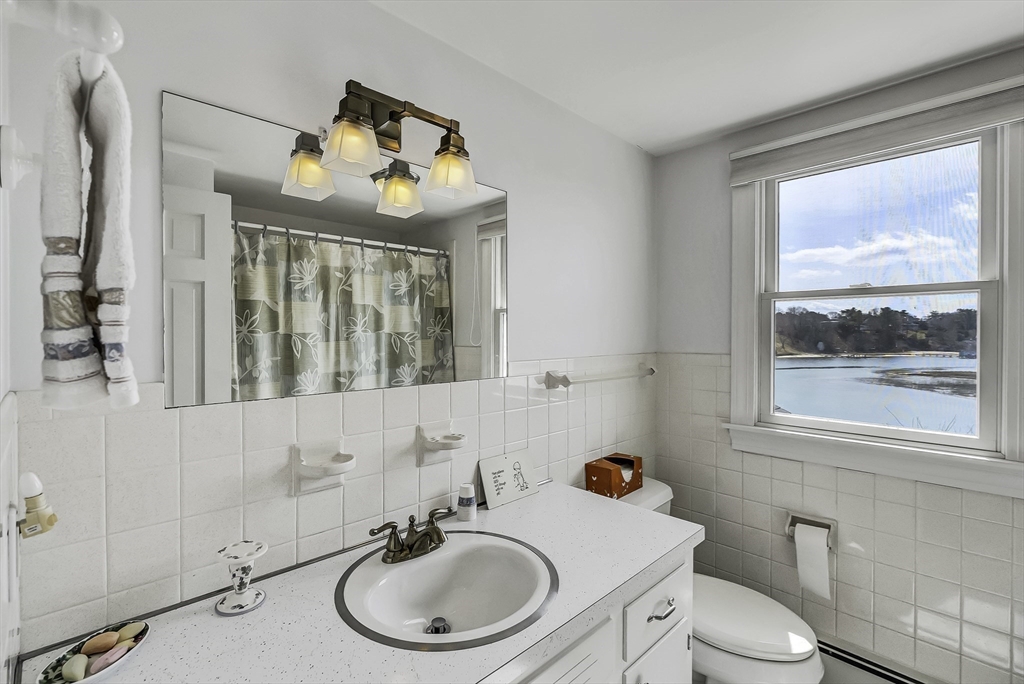 31 Baxendale Road Bourne, MA 02534 - Photo 27 of 36 a bathroom with a sink mirror toilet and next to a window