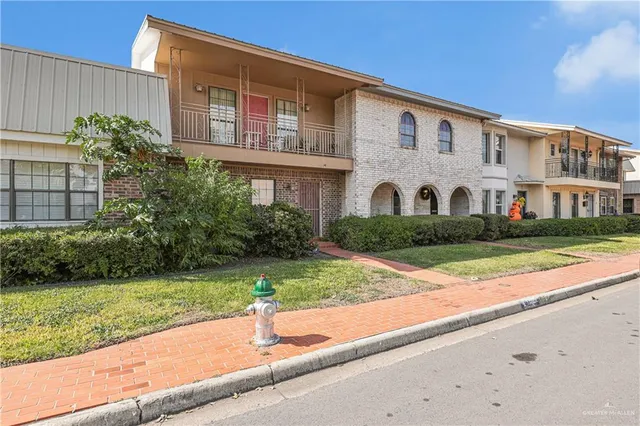 a front view of a house with a yard and potted plants