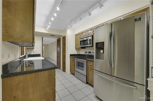 a kitchen with kitchen island a counter top space stainless steel appliances and cabinets