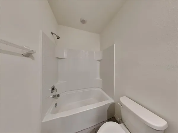 a white toilet sitting next to a bath tub