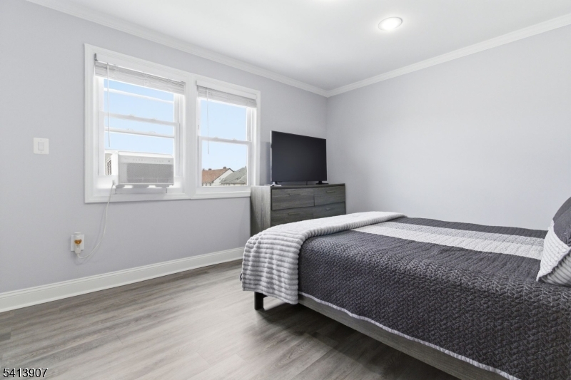 32 Cedar Avenue Elizabeth, NJ 07202 - Photo 20 of 32 a bedroom with a bed and a flat tv screen on a dresser