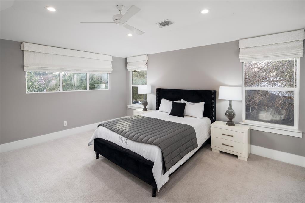 5811 Meletio Lane Dallas, TX 75230 - Photo 22 of 31 a spacious bedroom with a bed and a window
