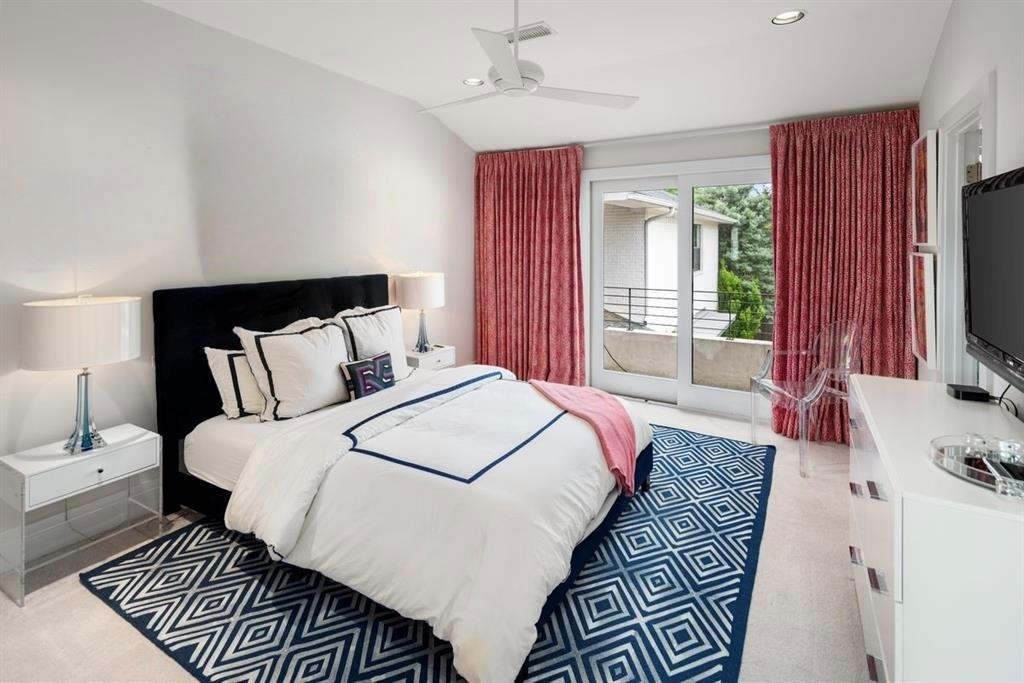 5811 Meletio Lane Dallas, TX 75230 - Photo 23 of 31 a spacious bedroom with a bed a flat screen tv and a couch