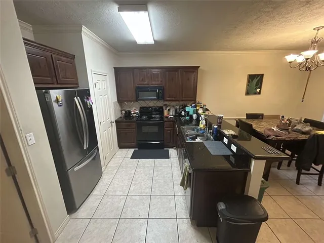 a kitchen with a sink a refrigerator and chairs
