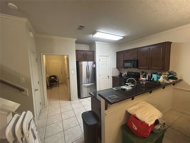 a kitchen with stainless steel appliances granite countertop a sink refrigerator and microwave