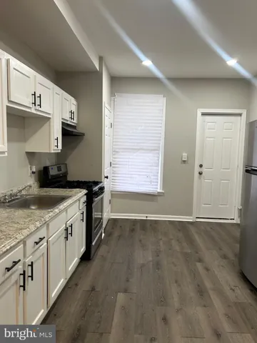 a kitchen with granite countertop a stove and a sink
