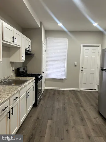 a kitchen with granite countertop a stove and a sink
