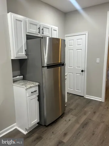 a white refrigerator freezer and a wooden floor