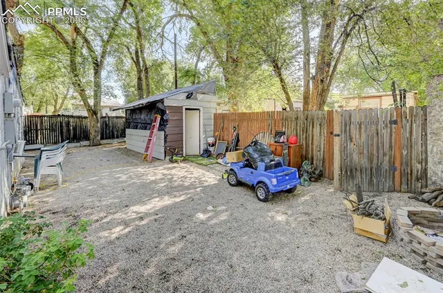 a view of a backyard with a fire pit and trees