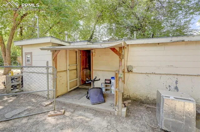 a view of a small barn in the back yard of the house