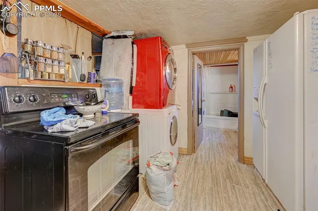 a kitchen with a sink a refrigerator and wooden floor