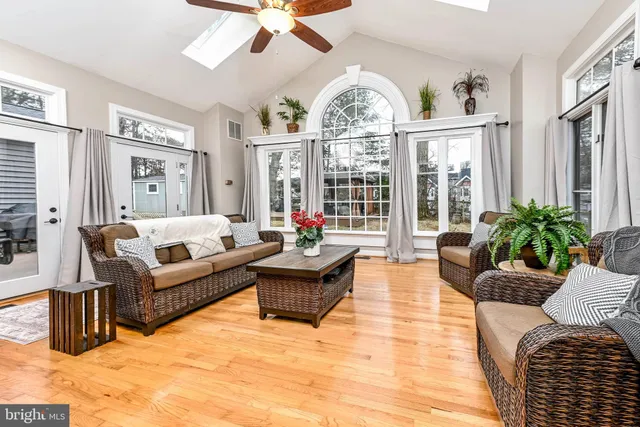 a living room with furniture ceiling fan and a window