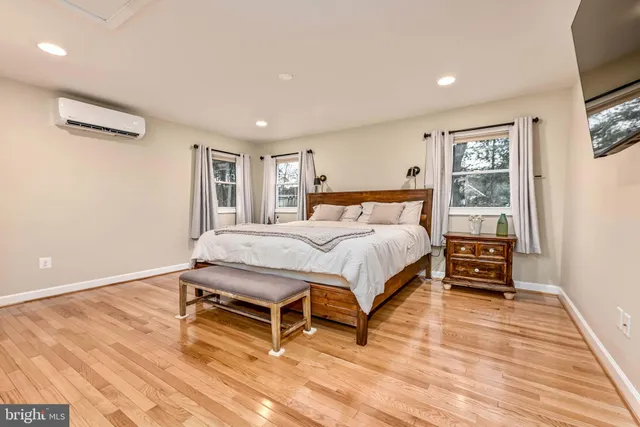 a spacious bedroom with a bed and a flat screen tv