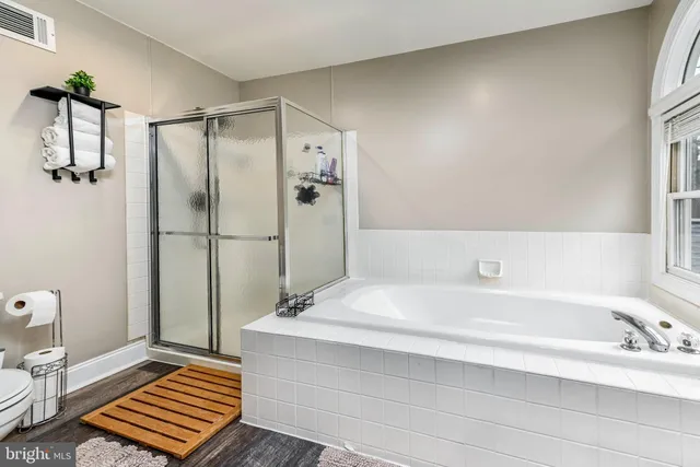 a spacious bathroom with a double vanity sink a mirror and a bathtub