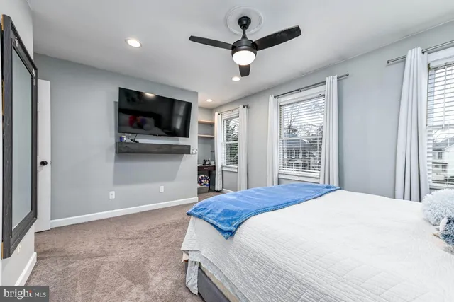 a bedroom with a bed a chair and a chandelier