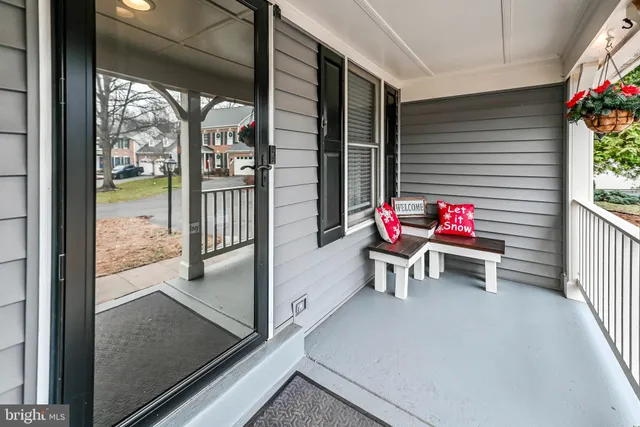 a view of a porch with a dining table chairs and potted plants