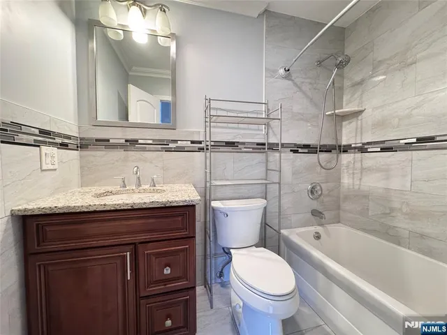a bathroom with a granite countertop toilet sink and mirror