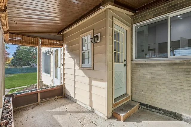 a view of a porch with a table and chairs