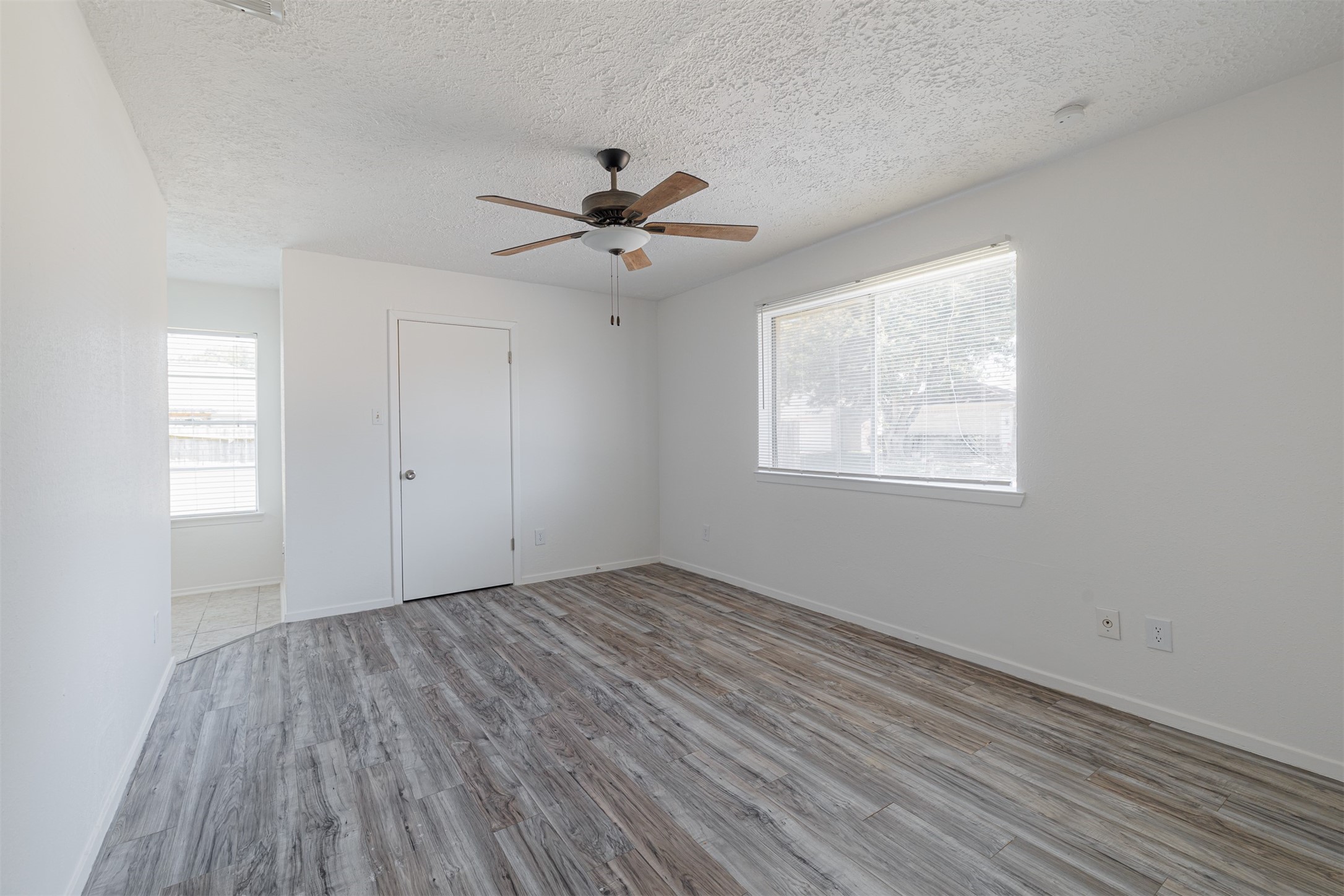 16702 Pebbleglen Drive Houston, TX 77095 - Photo 12 of 17 a view of empty room with wooden floor and fan