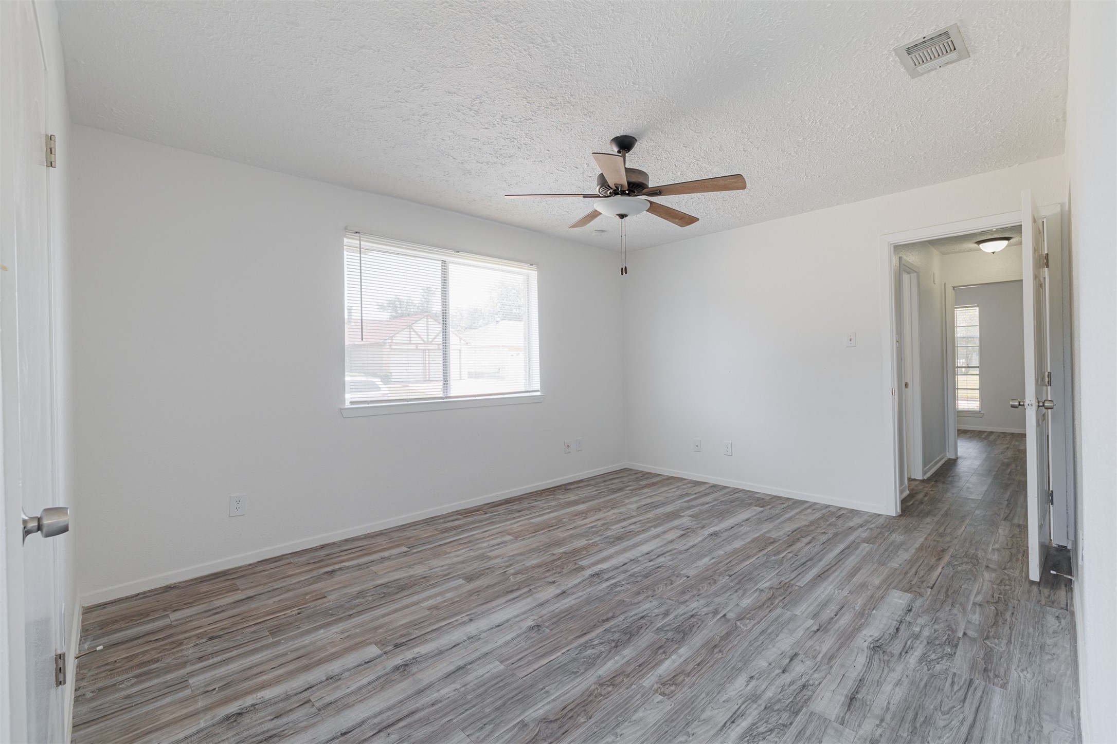16702 Pebbleglen Drive Houston, TX 77095 - Photo 13 of 17 a view of an empty room with wooden floor and a window