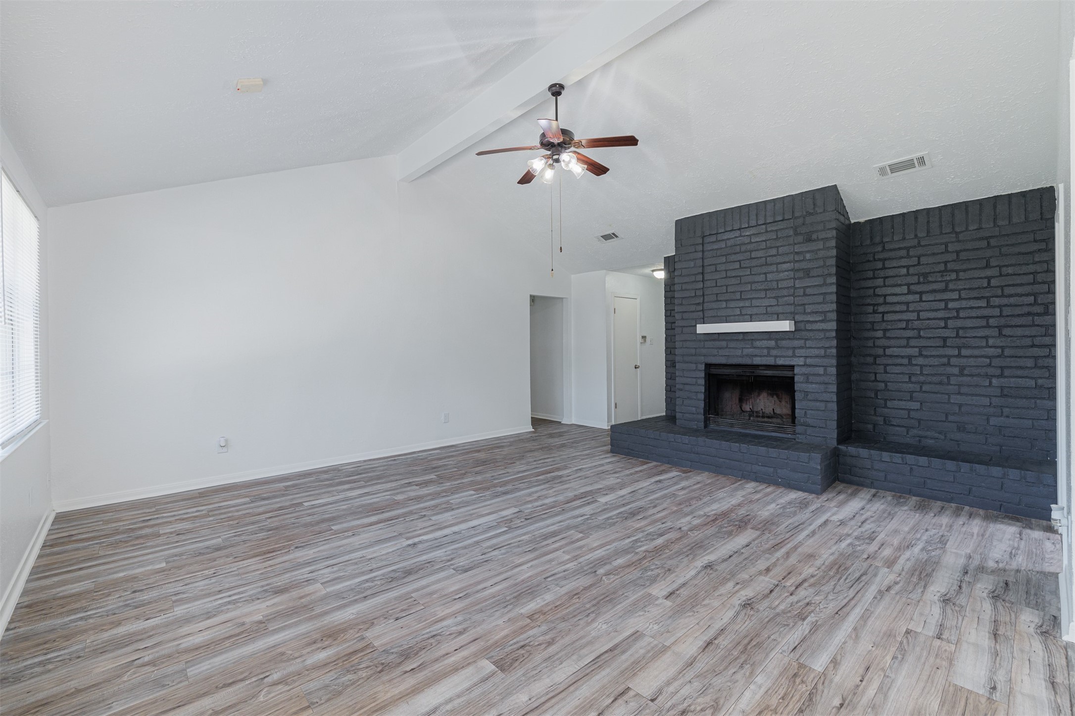 16702 Pebbleglen Drive Houston, TX 77095 - Photo 4 of 17 a view of empty room with wooden floor and fireplace