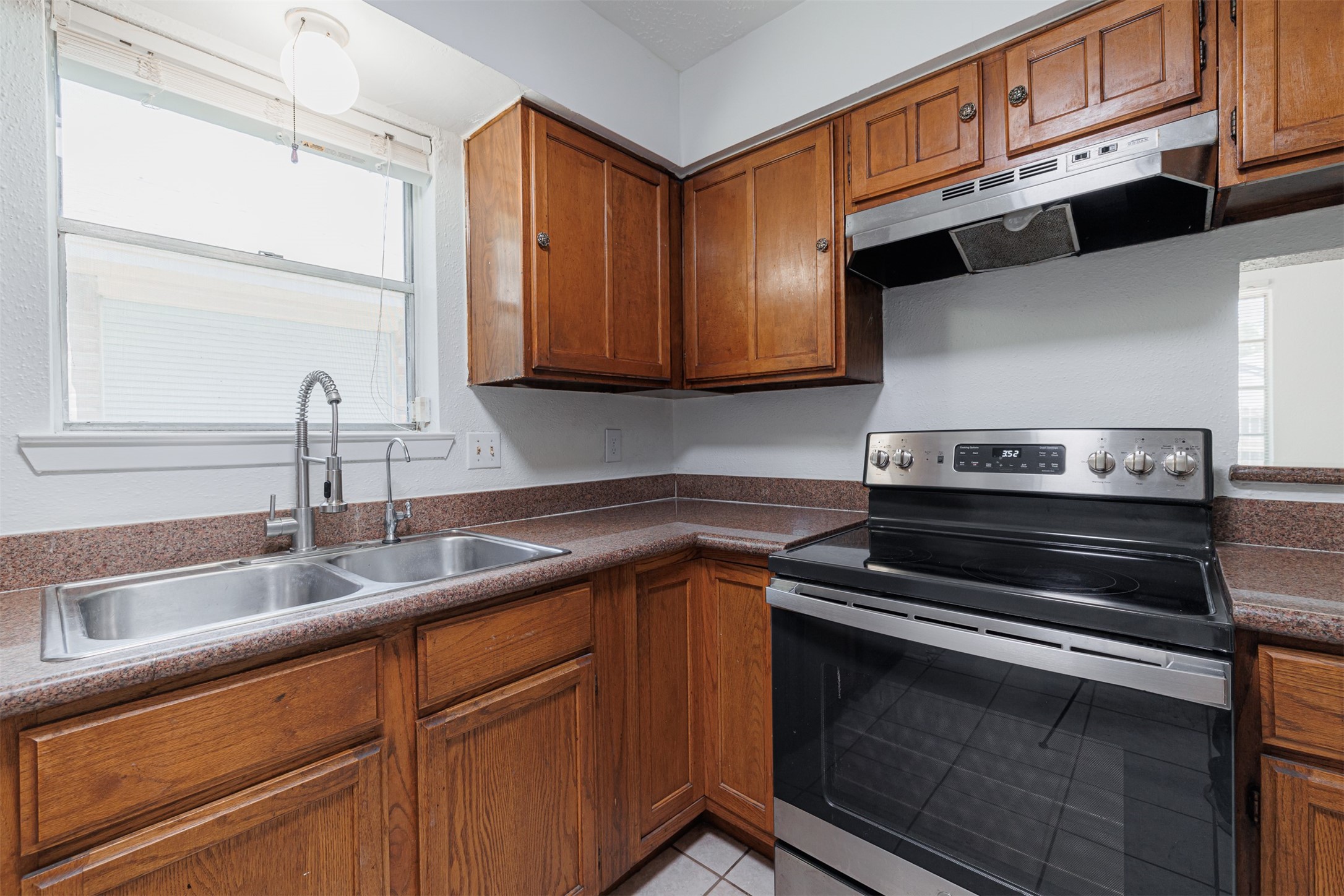 16702 Pebbleglen Drive Houston, TX 77095 - Photo 6 of 17 a kitchen with a sink stove and cabinets