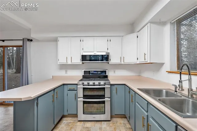 a kitchen with appliances a sink and cabinets