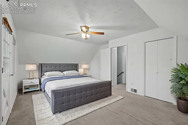 a bedroom with a bed and a potted plant on the dresser