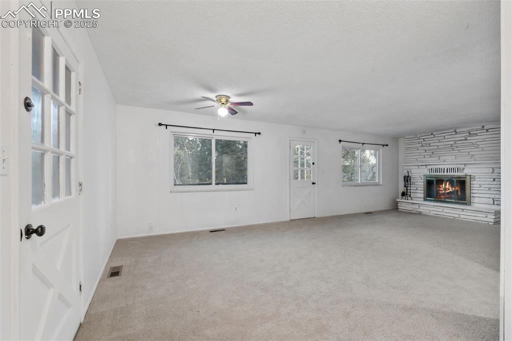 832 Spring Valley Drive Divide, CO 80814 - Photo 6 of 50 an empty room with windows and fireplace