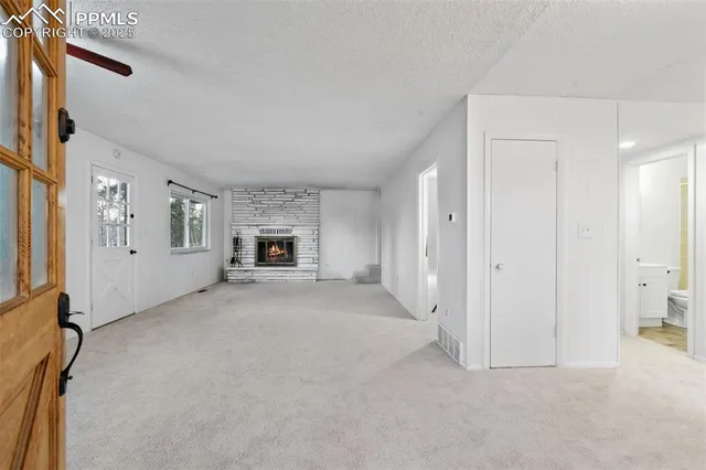 a view of a livingroom with a fireplace and window