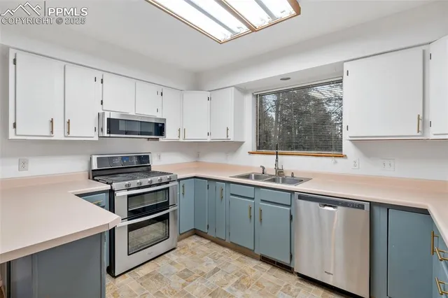 a kitchen with cabinets appliances a sink and a window
