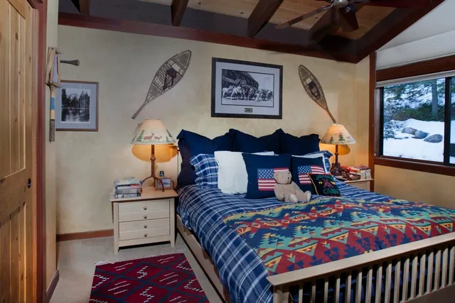 a bedroom with a bed and dresser with paintings on wall