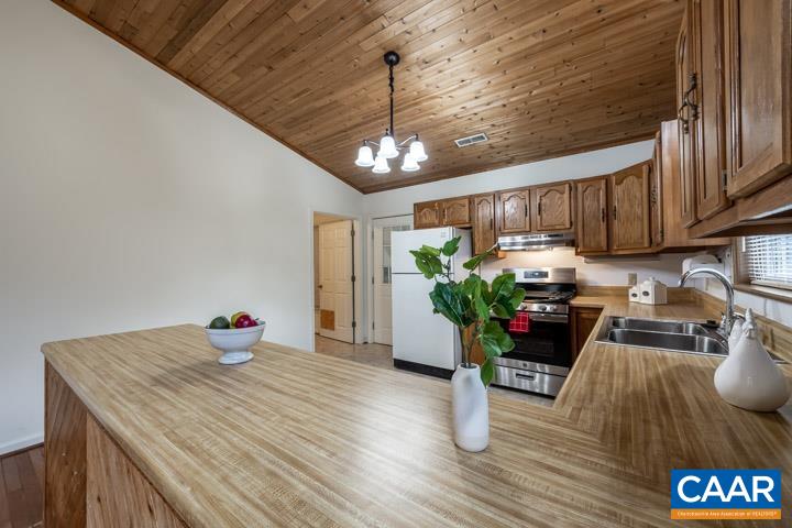 4657 Middle River Road Stanardsville, VA 22973 - Photo 21 of 40 a kitchen with stainless steel appliances granite countertop a stove refrigerator a sink dishwasher a microwave oven and a dining table with wooden floor