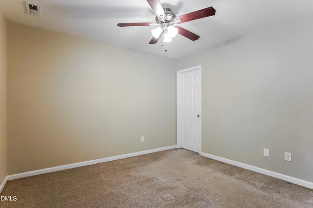 an empty room with a fan and a fan