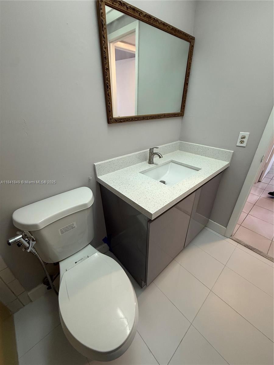 6820 West Flagler Street, Unit 407 Miami, FL 33144 - Photo 9 of 11 a bathroom with a toilet sink and mirror