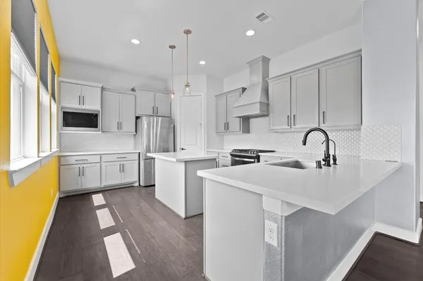 a kitchen with white cabinets and sink