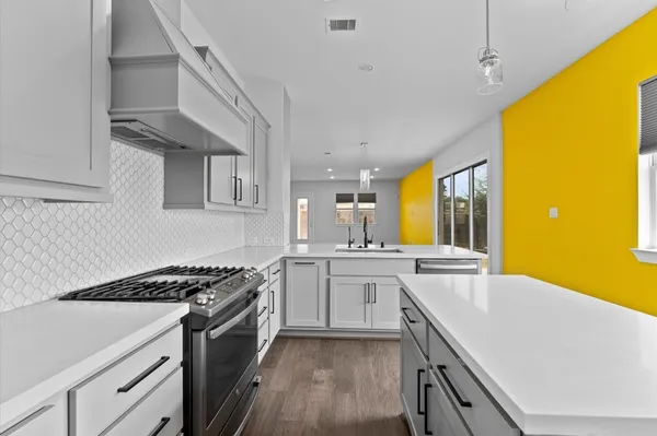 a kitchen with stainless steel appliances a sink a stove and a refrigerator