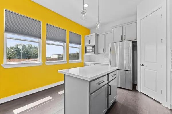 a kitchen with stainless steel appliances granite countertop a sink and a refrigerator