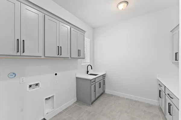 a kitchen with white cabinets and sink