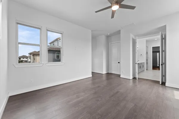 a view of an empty room with window and wooden floor