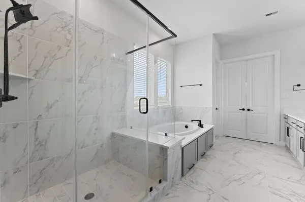 a bathroom with a double vanity sink a mirror and a bathtub